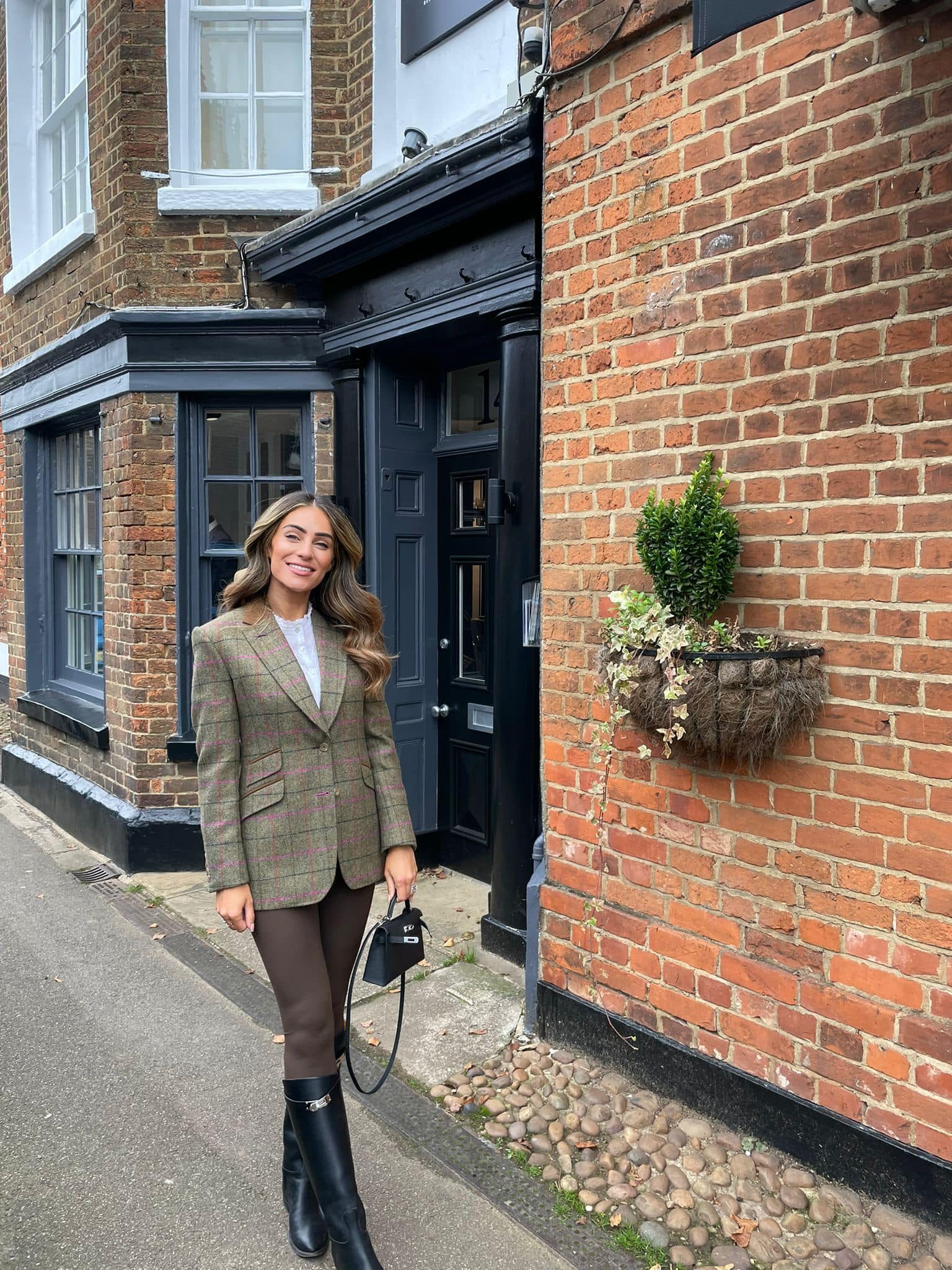 Client wearing a bespoke green check tweed jacket outside the Souster & Hicks shop in Woburn